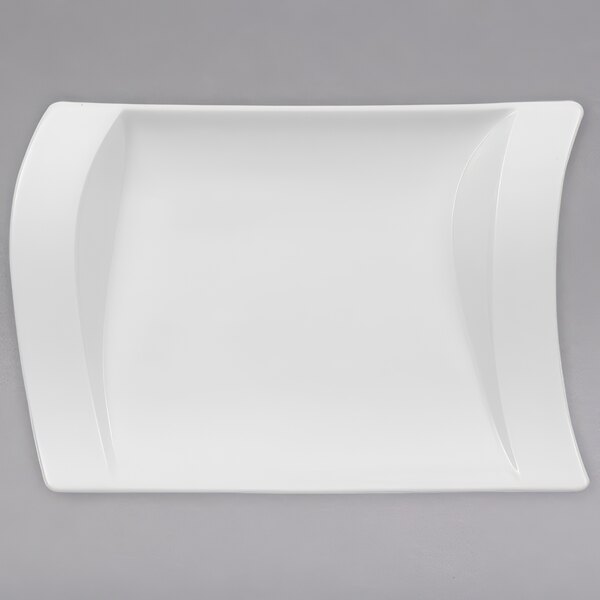 A close up of a Villeroy & Boch NewWave white porcelain pickle dish with a curved edge.