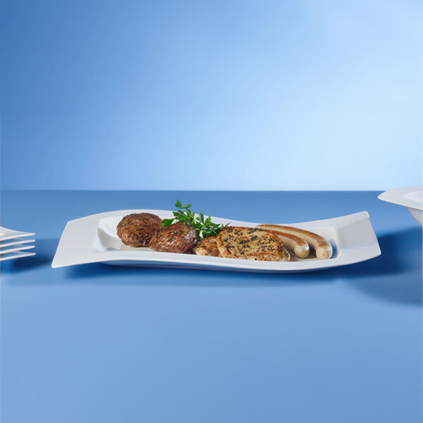 A Villeroy & Boch white porcelain platter with meat and sausages on it.