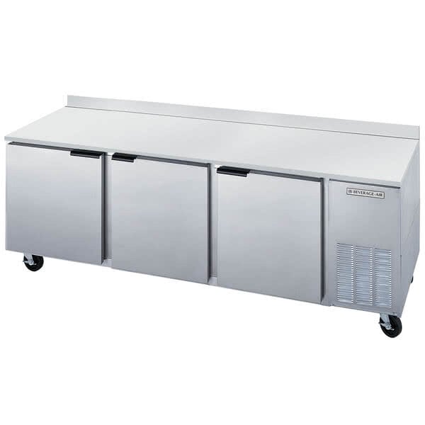 A Beverage-Air stainless steel worktop refrigerator with three doors.