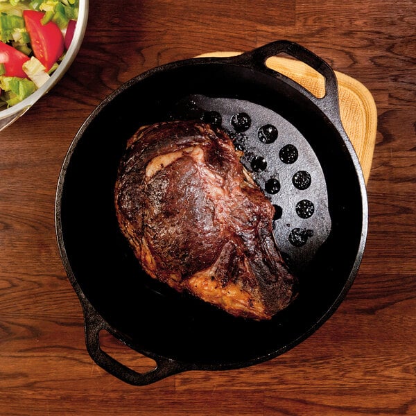 A Lodge cast iron trivet under a roast in a pan.