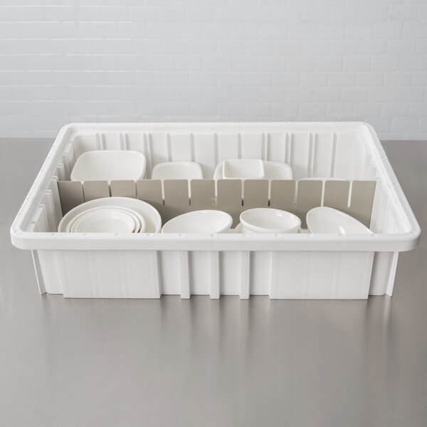 A gray Long Metro tote box divider with white plates and bowls inside.