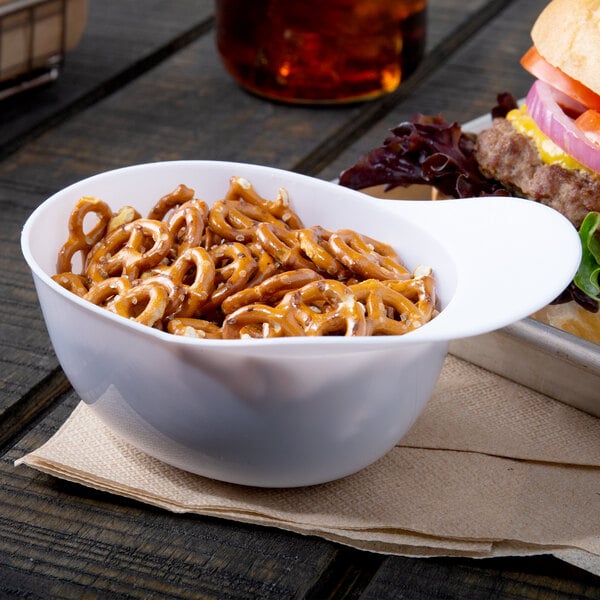 A white mini baseball helmet bowl filled with pretzels.