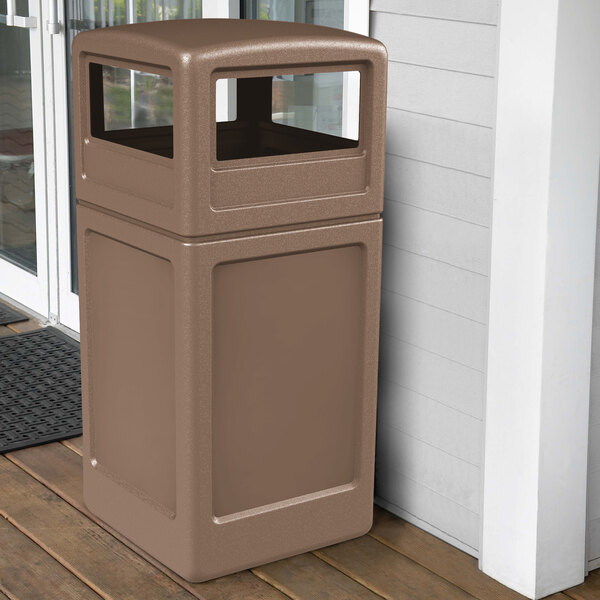 A brown Commercial Zone PolyTec waste container on a porch.