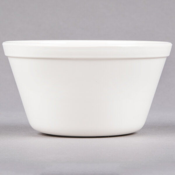 A white Carlisle polycarbonate bouillon cup on a grey surface.