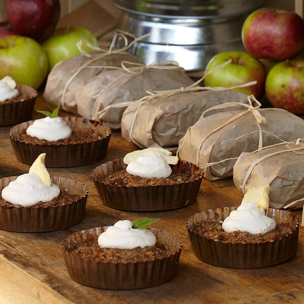 Solut paper baking cups filled with desserts on a table.