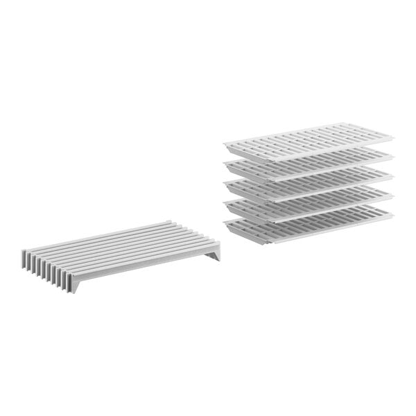 A stack of white metal shelves with vented surfaces.