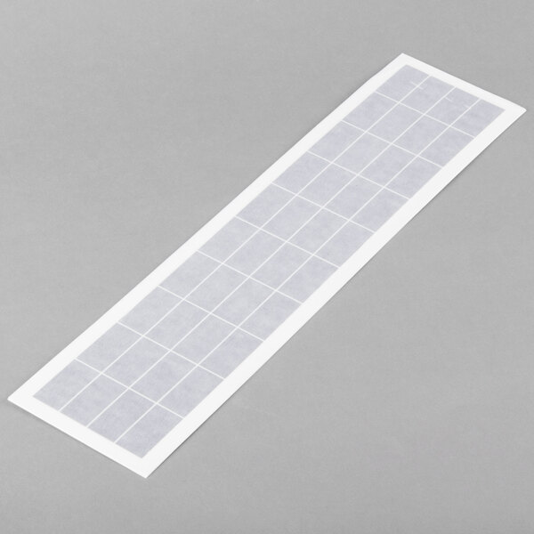 A rectangular white sticker with a grid pattern.