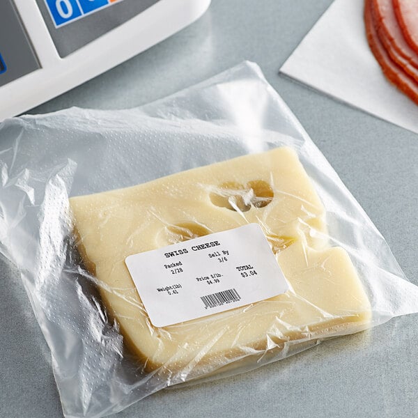 A package of Cardinal Detecto white thermal labels on a counter near a piece of cheese.