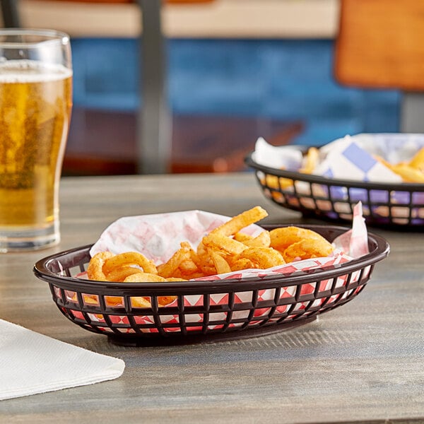 A Tablecraft brown plastic oval basket filled with french fries on a table.