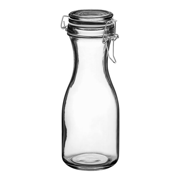 An Acopa clear glass carafe with a resealable metal lid.