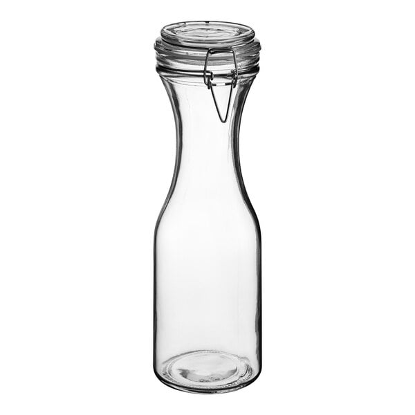 An Acopa clear glass carafe with a metal resealable lid.