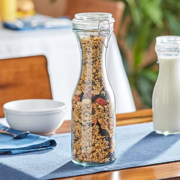 An Acopa glass carafe filled with cereal and berries on a table.