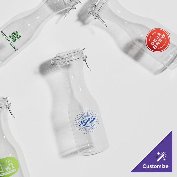 A group of Acopa clear glass carafes with lids.