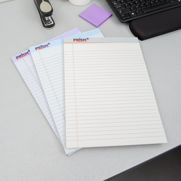 A desk with a TOPS Prism+ legal pad, pen, and keyboard.