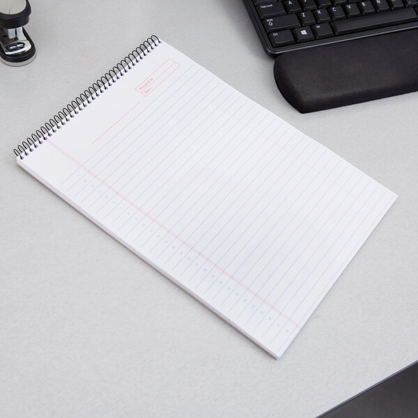 A TOPS Docket Gold spiral bound planner pad on a desk.