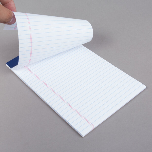 A person's hand holding a piece of college ruled paper from an Ampad writing pad.