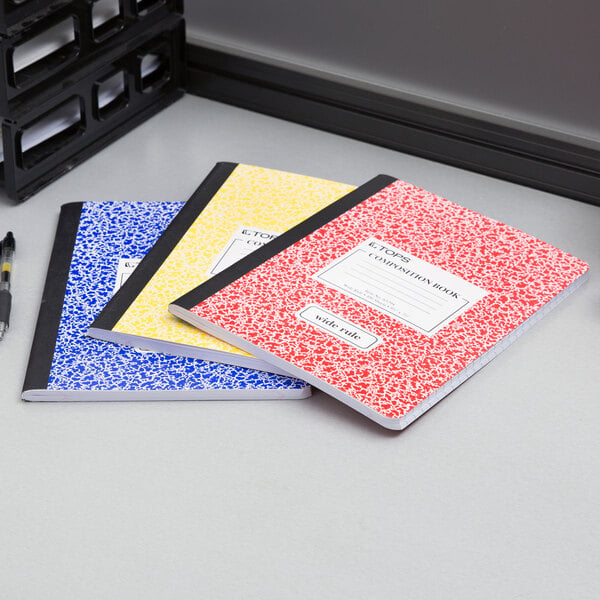 A group of TOPS composition books on a table.