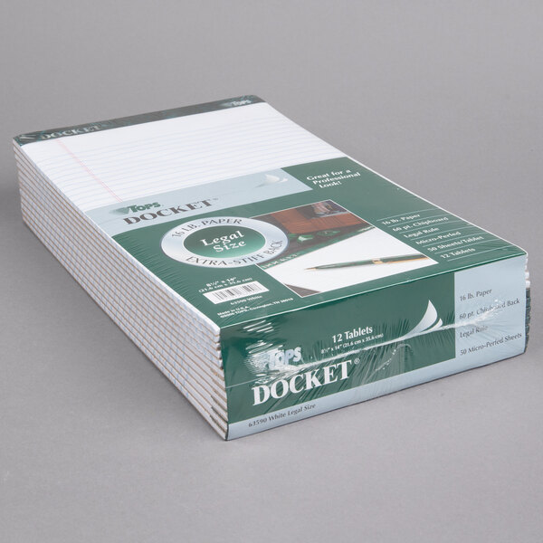 A stack of white TOPS Docket writing tablets on a gray surface.
