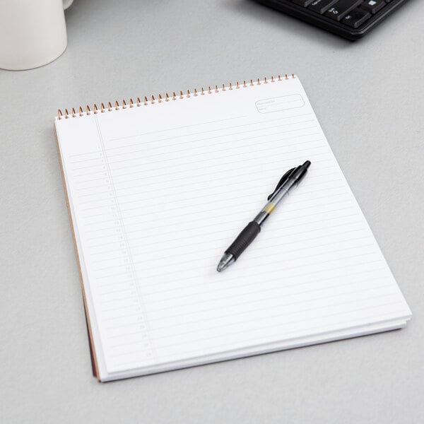 An Ampad Navy Wirebound Planner with a pen on top.