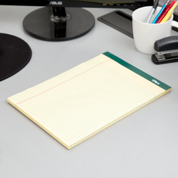 A TOPS Double Docket narrow ruled notepad on a desk.