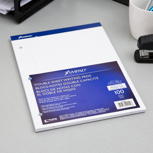 An Ampad white wide ruled 3-hole punched writing pad on a desk.