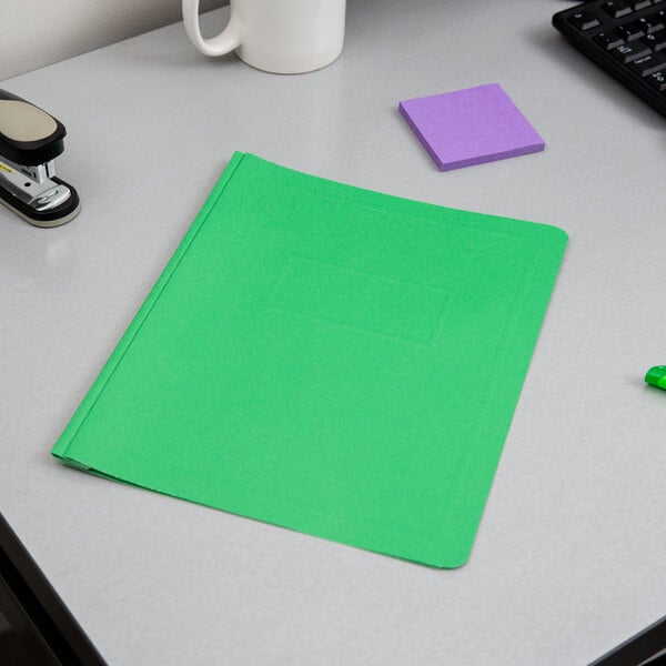 A green Oxford report cover with fasteners on a white surface.