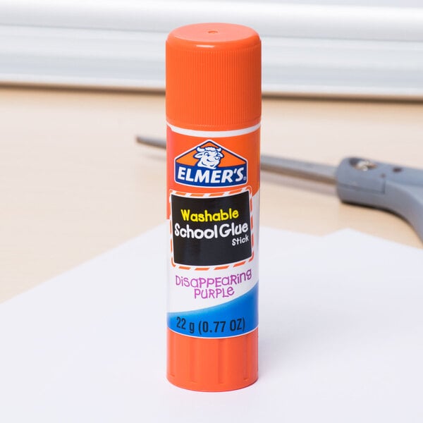 An orange Elmer's Disappearing Purple School Glue Stick on a table.