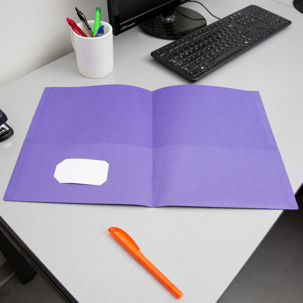 A purple Oxford 2-pocket folder on a desk.