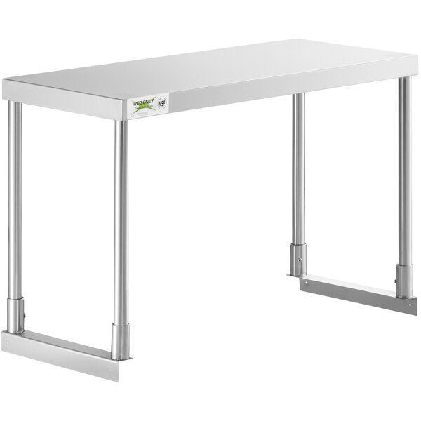 A Regency stainless steel single deck overshelf on a stainless steel work table.