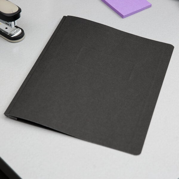 A black Oxford report cover with fasteners on a white surface.