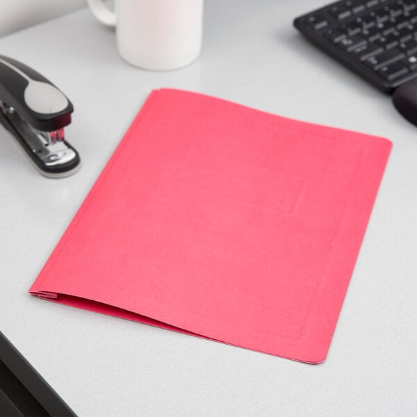 An Oxford red report cover on a white surface.