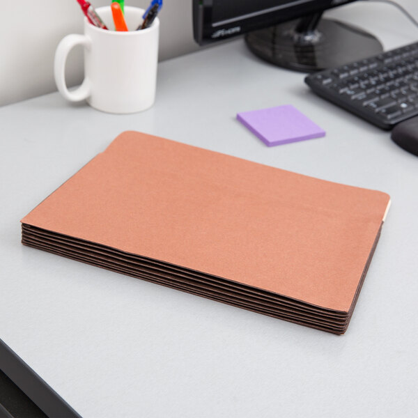 A stack of Pendaflex heavy-duty file pockets on a desk.