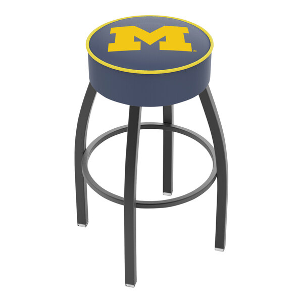 A Holland Bar Stool University of Michigan swivel bar stool with a yellow seat and blue logo.