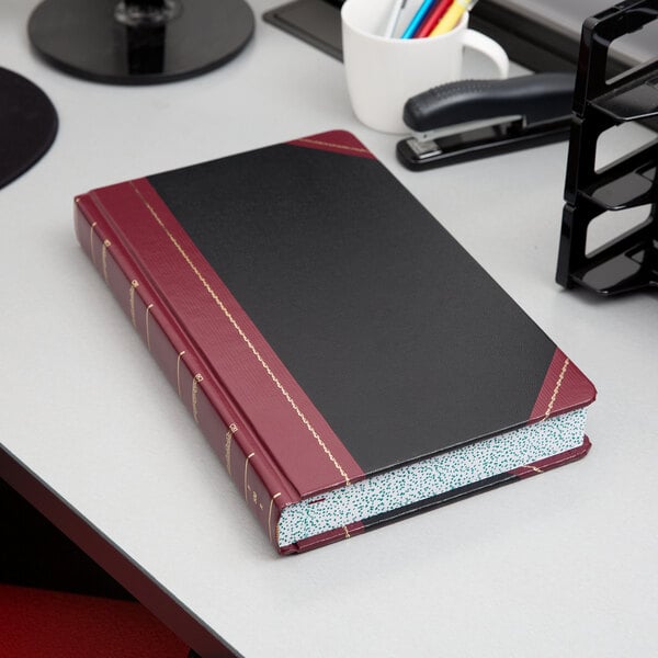 A black and red Boorum & Pease record and account book on a table.