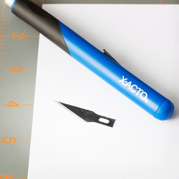 An X-Acto #11 knife blade on a piece of paper.