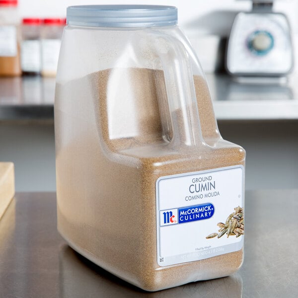 A plastic container of McCormick Culinary Ground Cumin.
