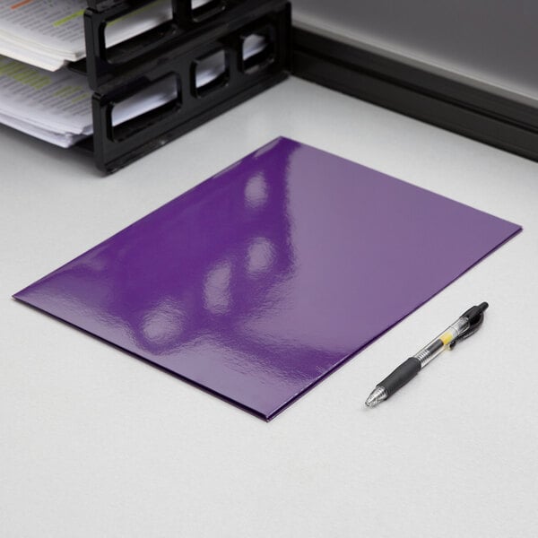 A purple Oxford 2-pocket folder with a pen on top of it.