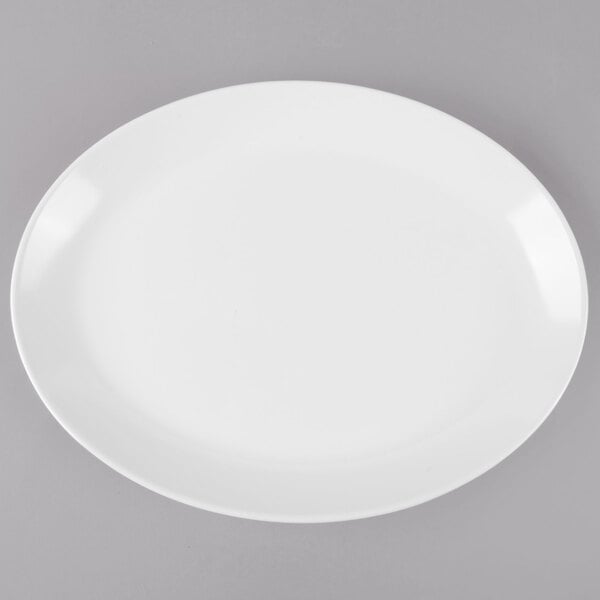 A white oval melamine platter with a white rim on a gray surface.