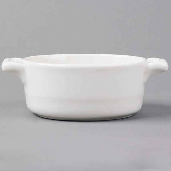 A white porcelain oval cocotte with handles.