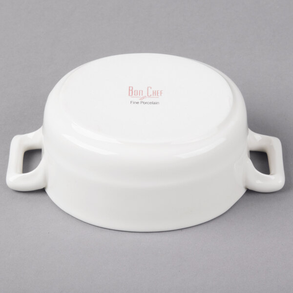 A white porcelain oval cocotte with handles.