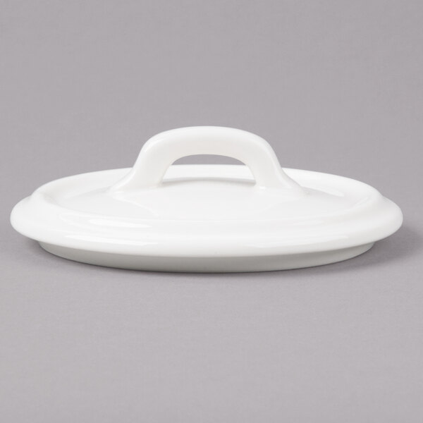 A white round Bon Chef porcelain lid with a handle.