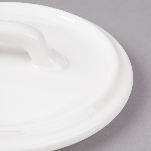 A white Bon Chef porcelain cocotte lid with a handle.