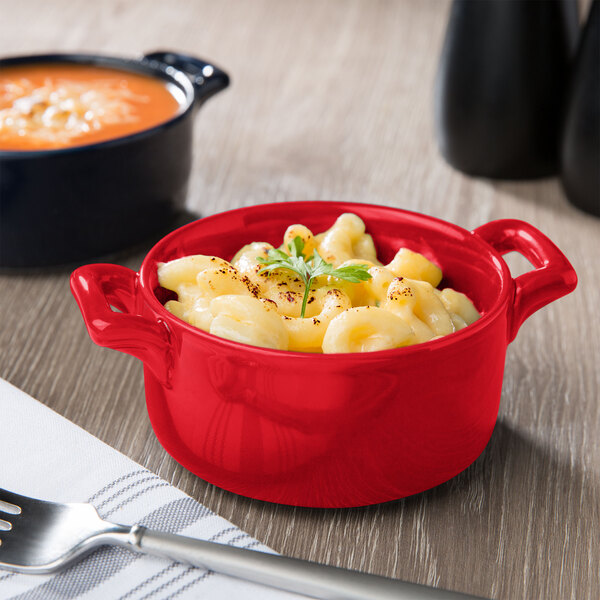 A red Bon Chef porcelain cocotte filled with macaroni and cheese.