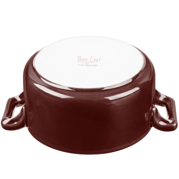A white porcelain casserole with brown accents and handles.