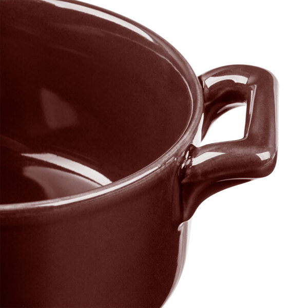 A close up of a Bon Chef burnt umber porcelain cocotte with a handle.