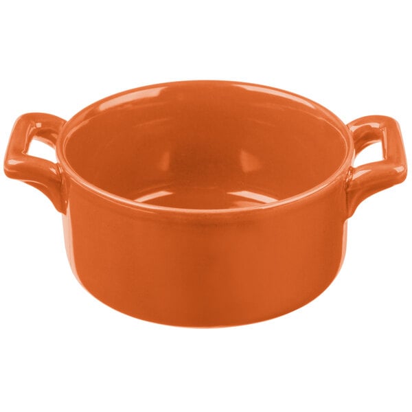 An orange porcelain Bon Chef cocotte with handles.