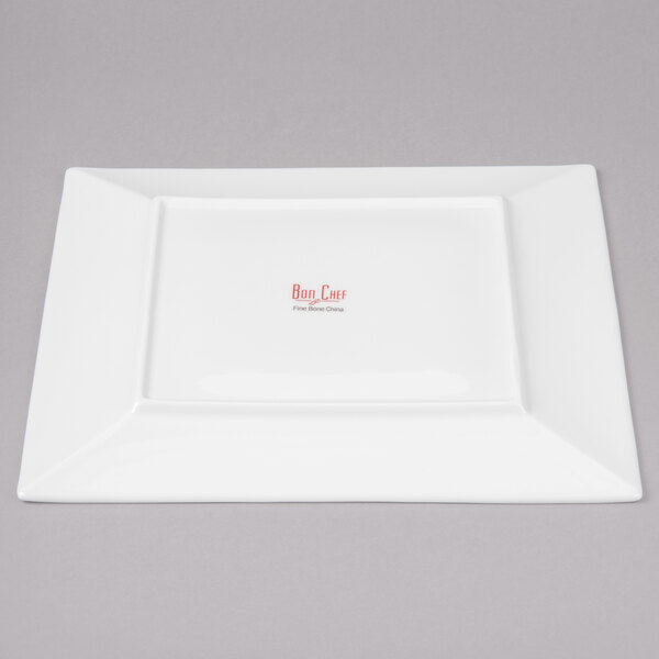 A white square Bon Chef bone china plate with red writing on it.