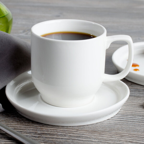 A white Bon Chef porcelain cup of coffee on a saucer.