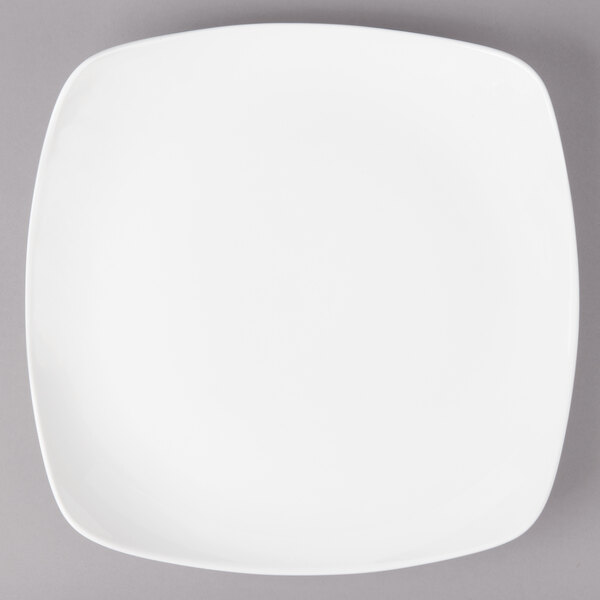 A white square Bon Chef porcelain dinner plate on a gray surface.