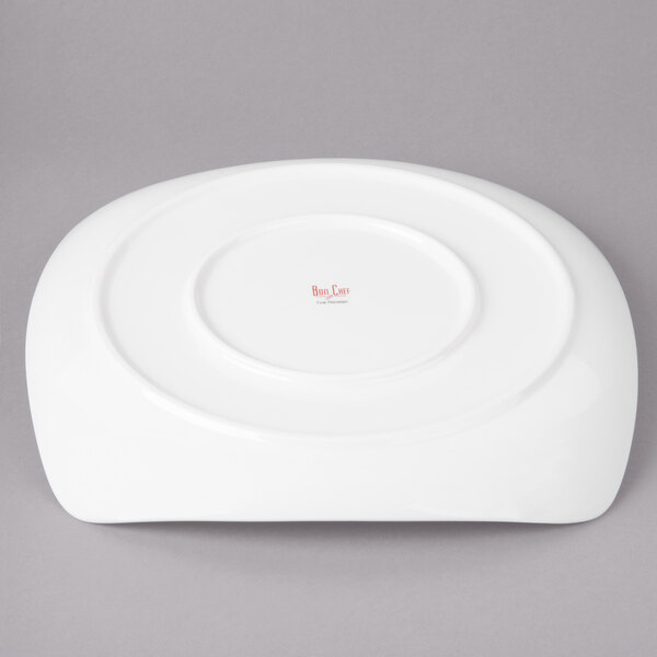 A white Bon Chef porcelain dinner plate with a round center on a gray background.